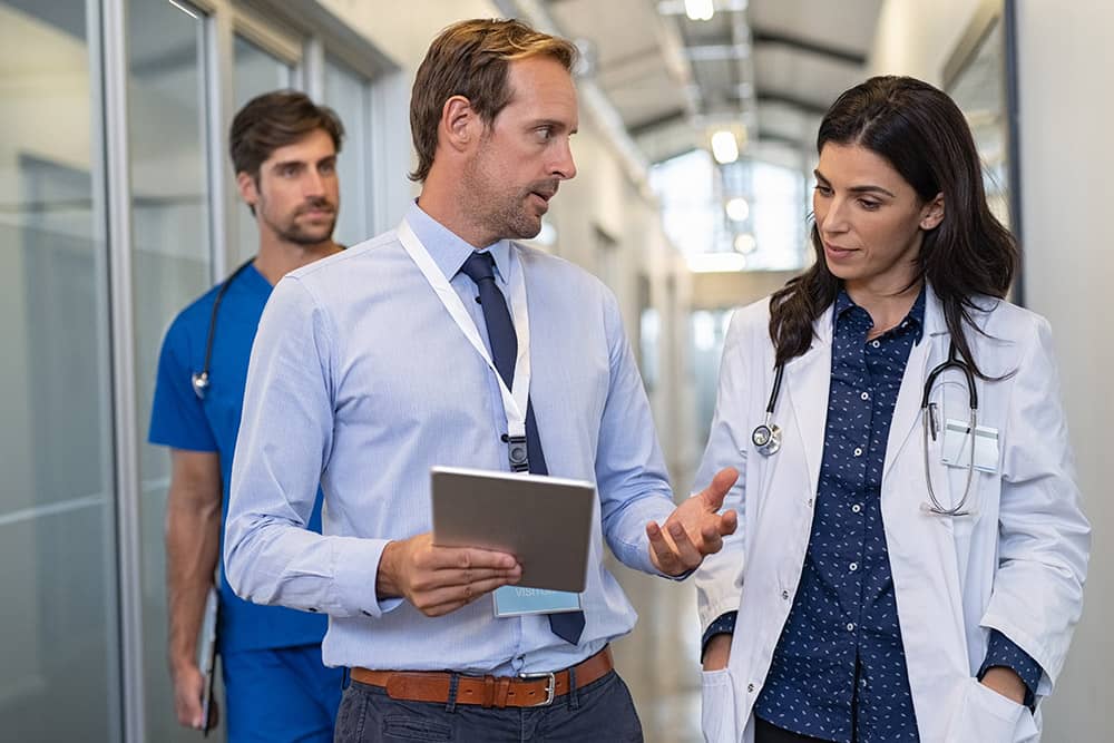Man and woman doctor having a discussion in hospital hallway.
